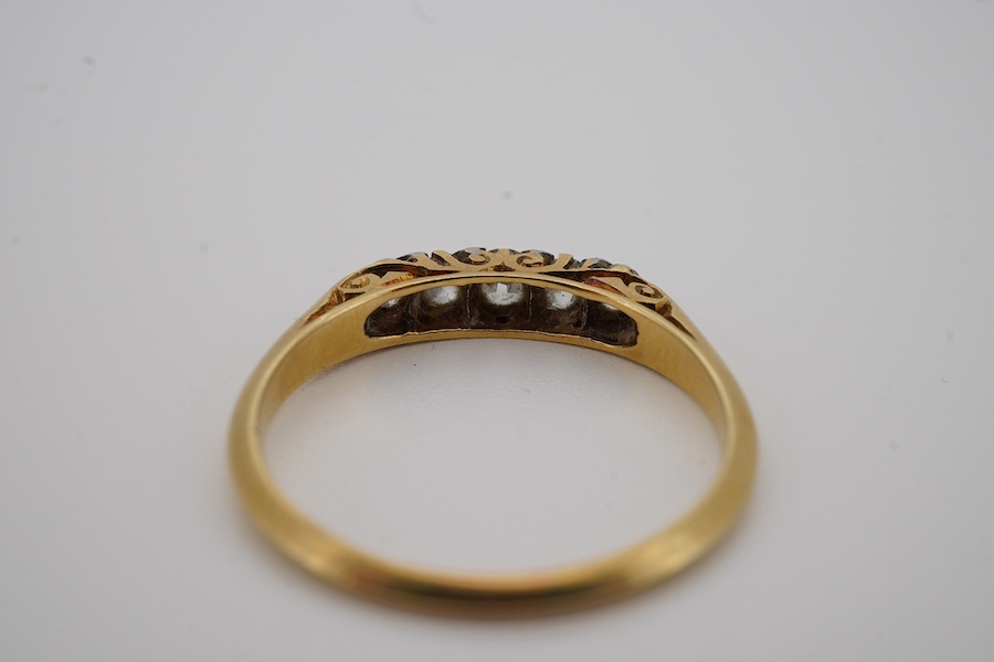 An early 20th century yellow metal and graduated five stone diamond set half hoop ring, size N, gross weight 2 grams. Condition - fair